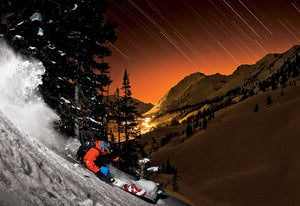 Open image in slideshow, Bryce Phillips skiing powder at night under star trails in the Alta backcountry
